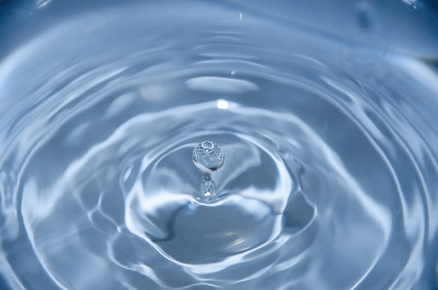 Water droplet creating ripples on a calm water surface